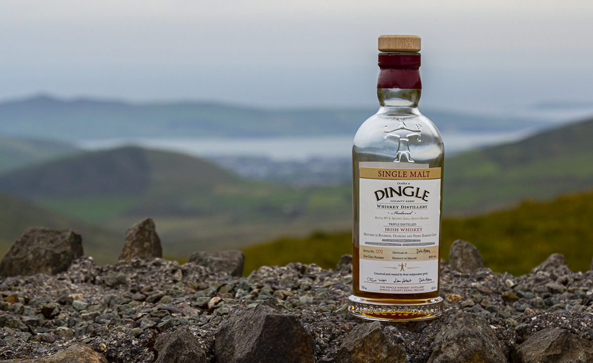 A bottle of Dingle Whiskey on a wall overlooking the town of Dingle, Ireland. Photo ©2019, Mark Gillespie/CaskStrength Media.