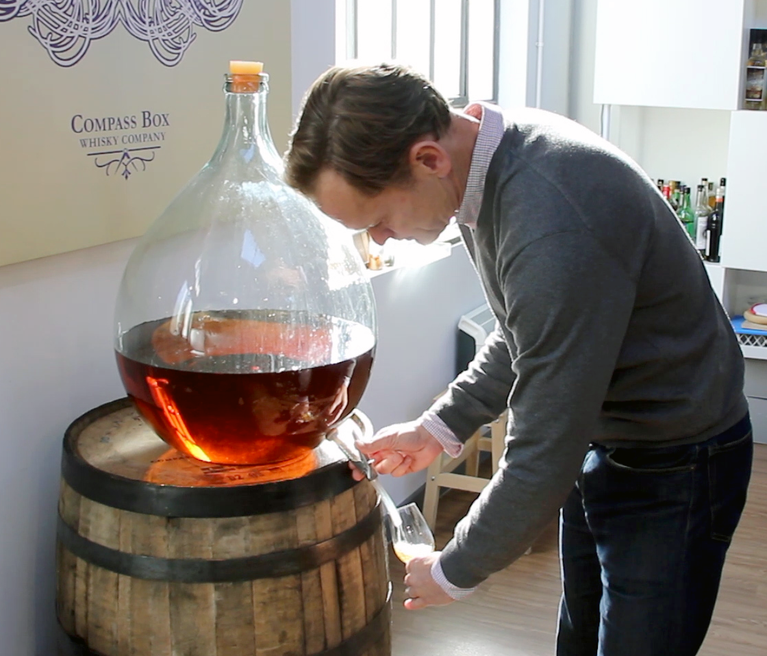 Compass Box Whisky founder John Glaser pours a dram from one of the glass demijohns used for holding samples in the Compass Box blending lab in London. File photo ©2020, Mark Gillespie/CaskStrength Media.