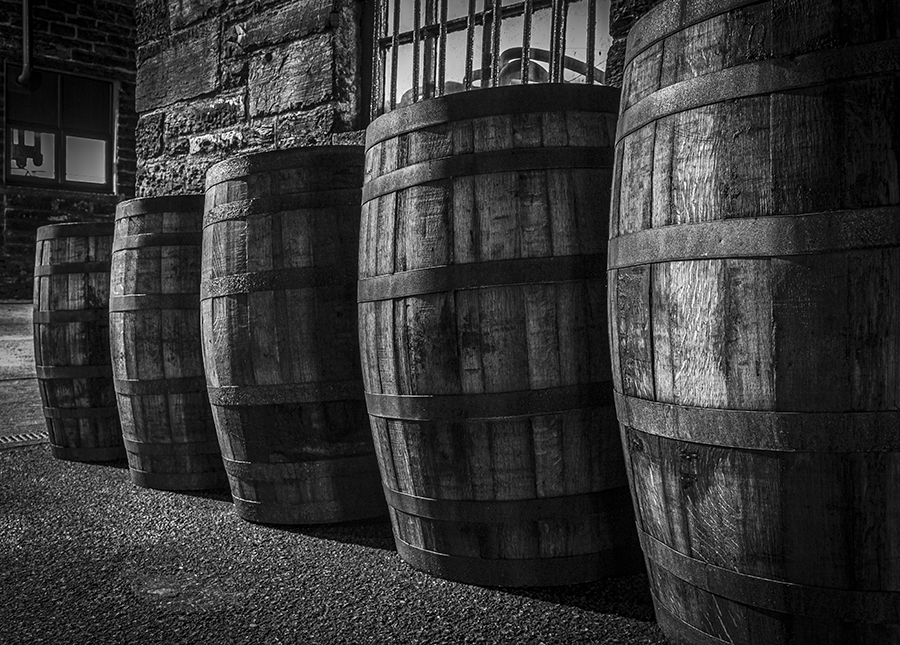 Most people don't get the chance to look around distilleries at night, when the shadows can take an ordinary row of barrels and emphasize the texture in both the wood of the barrels and the stone walls of the Pulteney Distillery still house in Scotland.